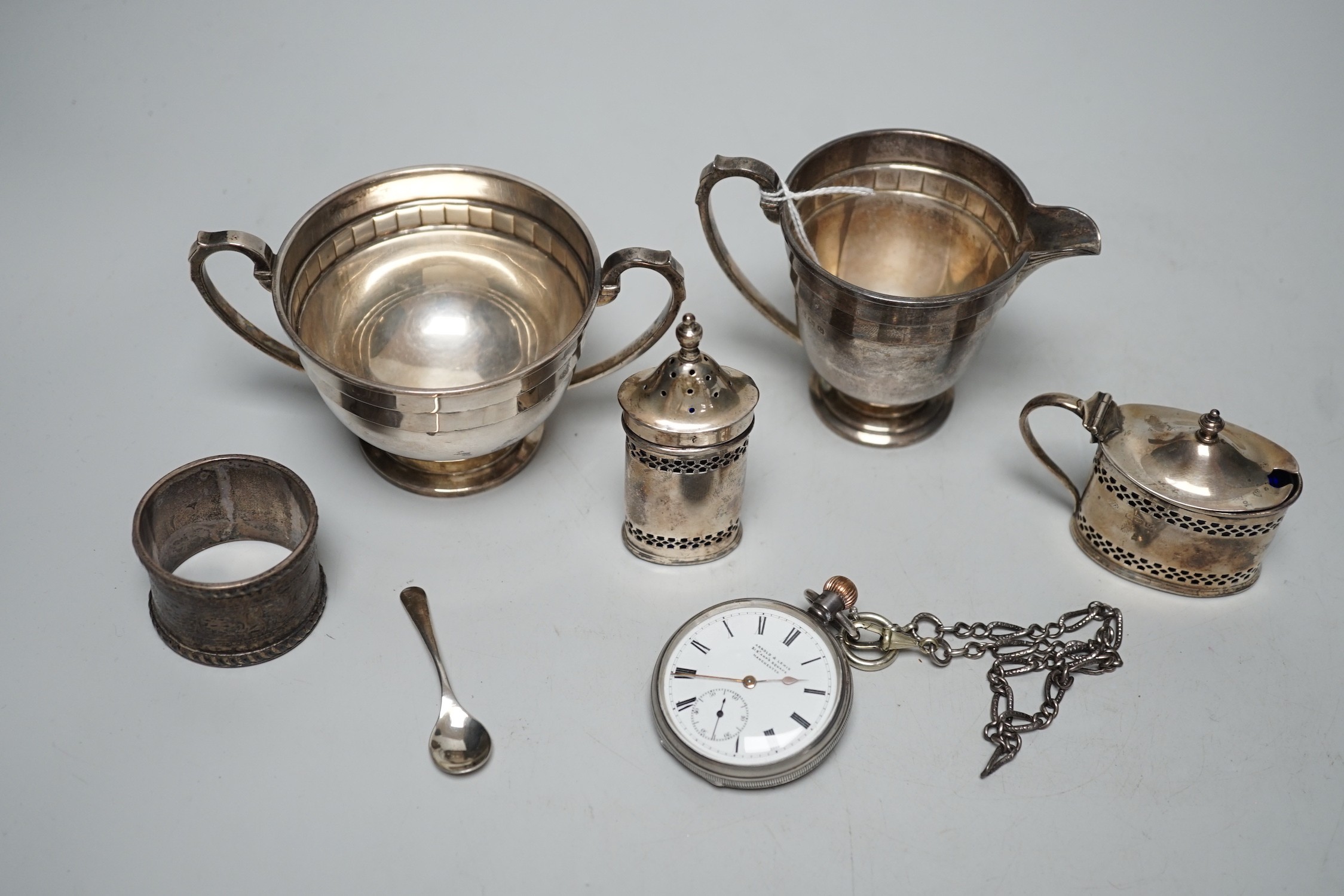 Small silverware, including a George V cream jug and matching sugar bowl, a mustard pot and matching pepper pot, silver serviette ring and a gentleman’s silver pocket watch and chain.